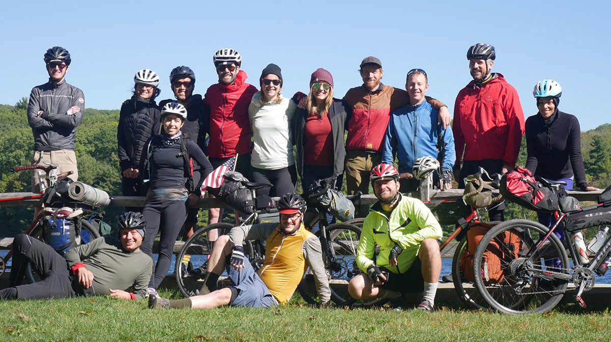 Large group of cyclists by fence