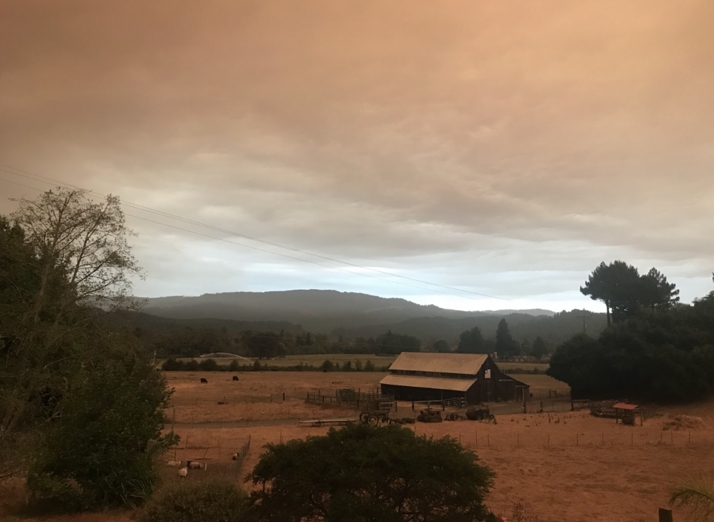 A farm setting with orange/brown low clouds.