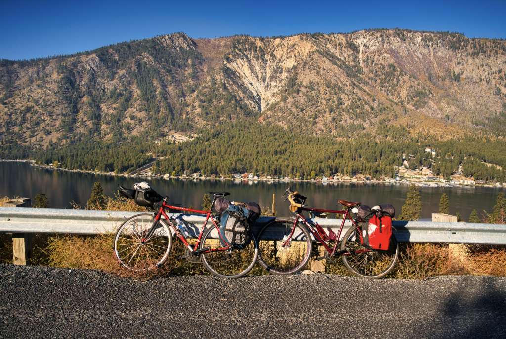 Two loaded bicycles without riders leaning against the gaurdrail on a sunny day in the Columbia Gorge.